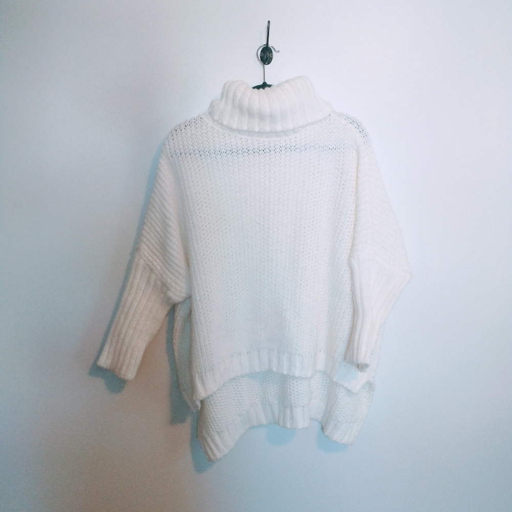 Cream turtleneck sweater with oversized cozy fit and longer hem in the back.  Wo